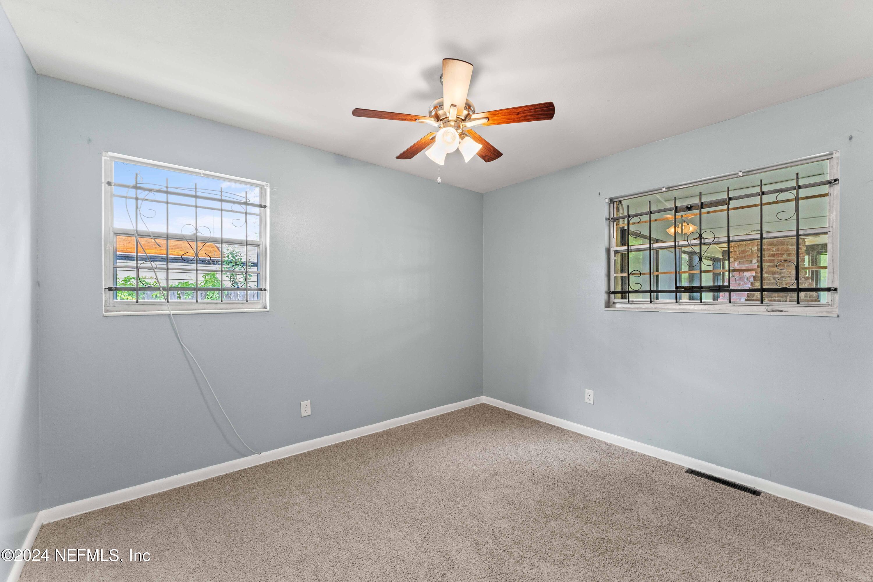 8545 Addison Road Jacksonville, FL 32208 - Photo 14 of 26 an empty room with windows and fan