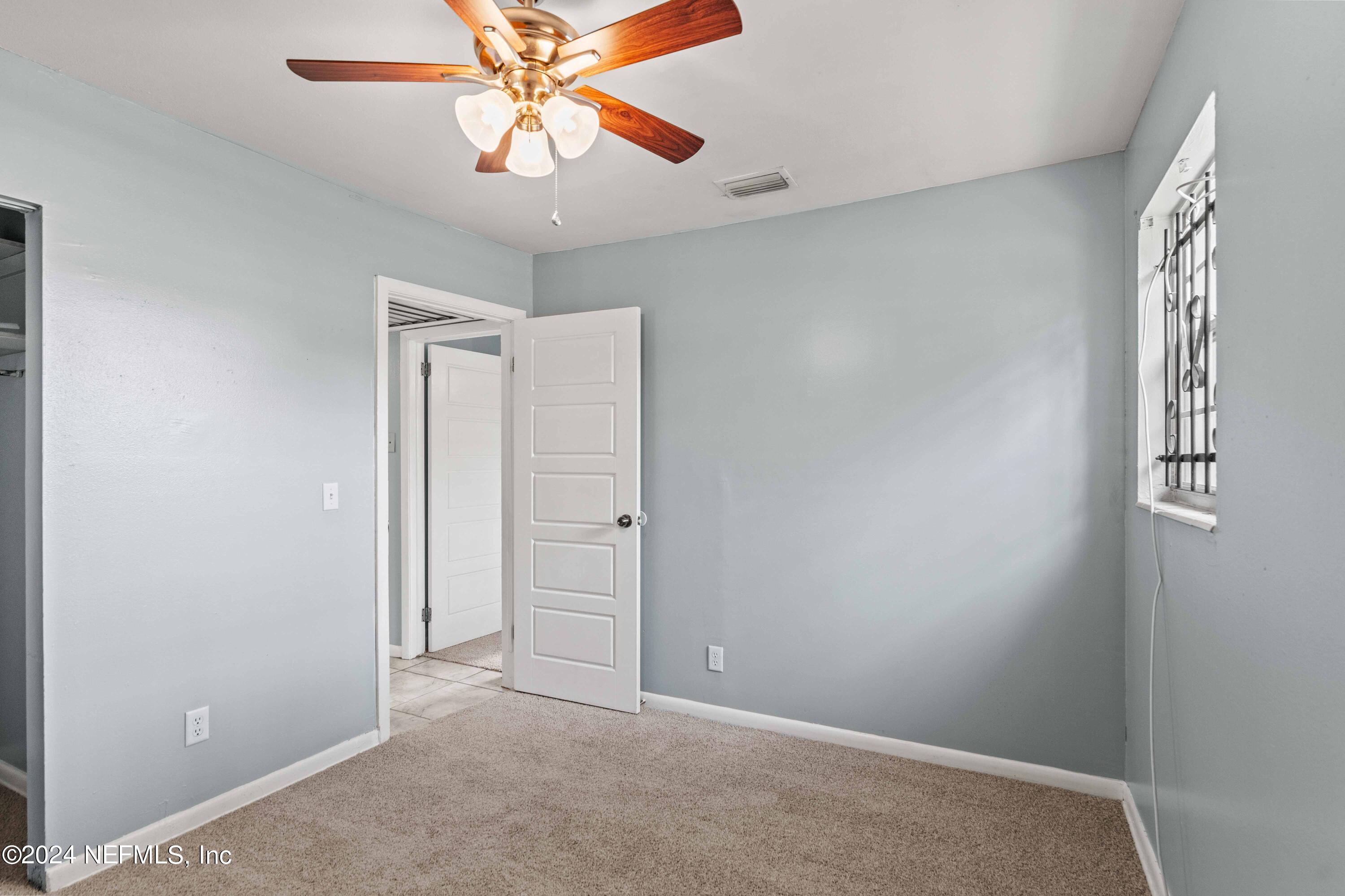 8545 Addison Road Jacksonville, FL 32208 - Photo 15 of 26 an empty room with windows and fan