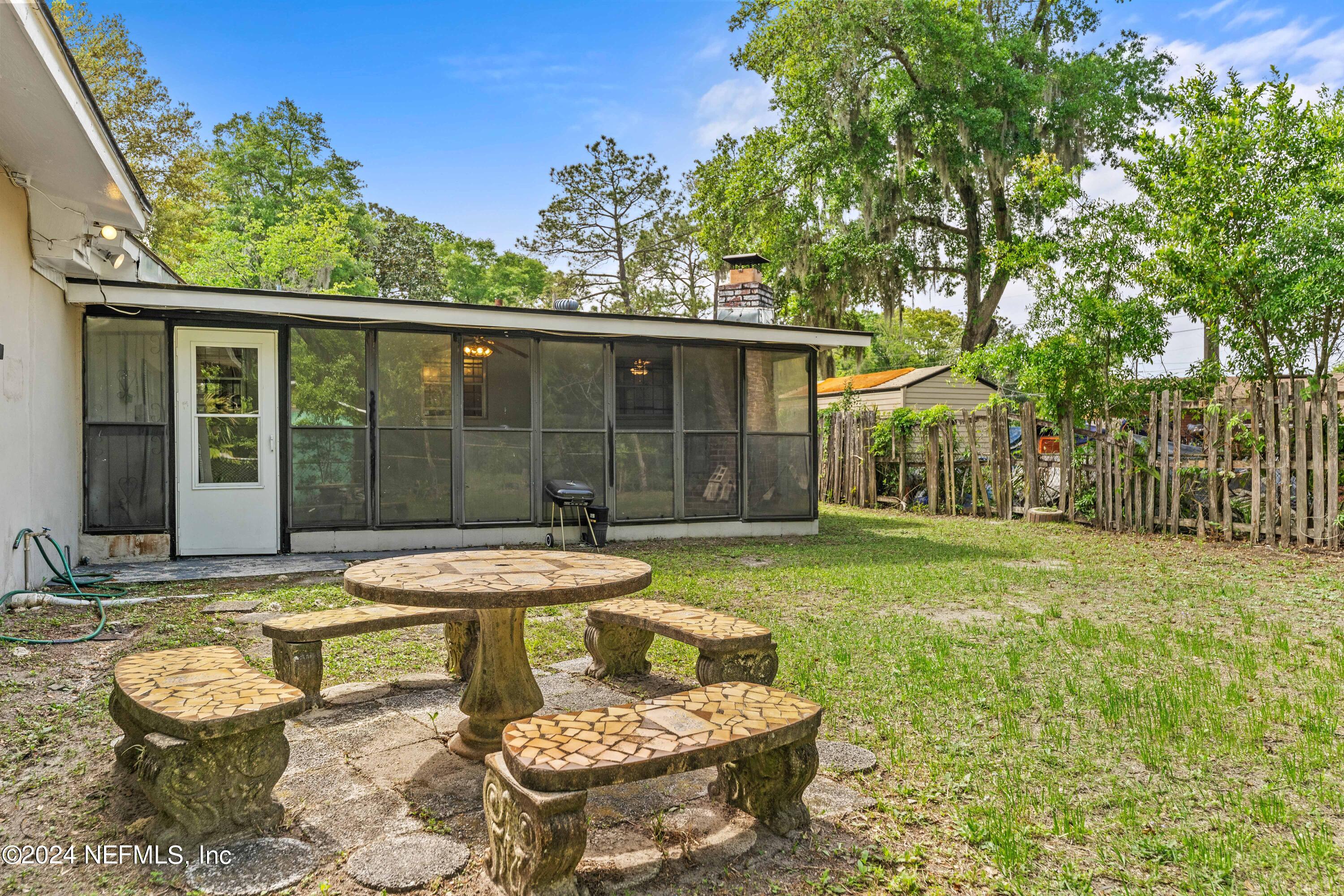 8545 Addison Road Jacksonville, FL 32208 - Photo 24 of 26 a view of a patio with table and chairs and potted plants with wooden fence