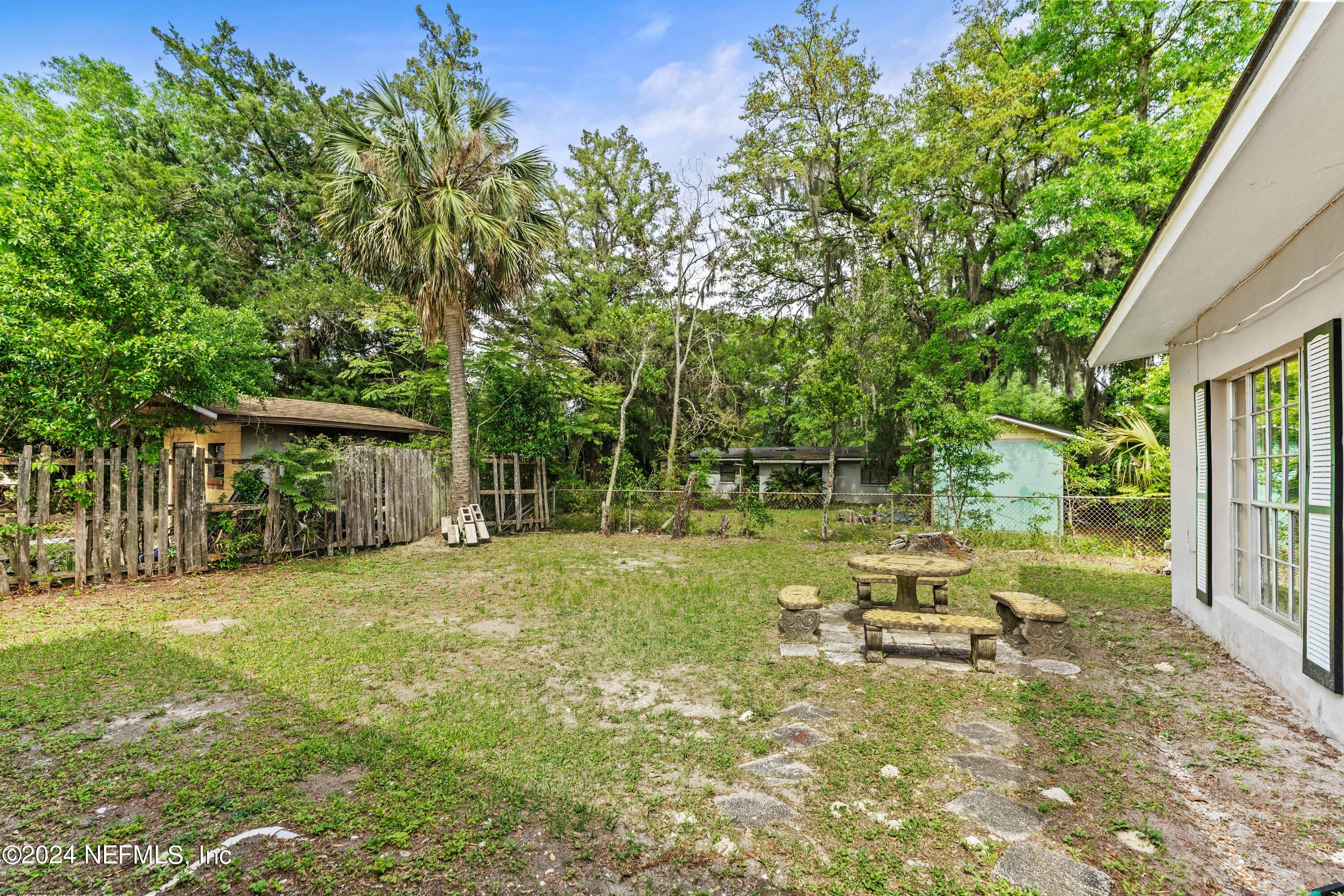8545 Addison Road Jacksonville, FL 32208 - Photo 25 of 26 a backyard of a house with table and chairs and potted plants