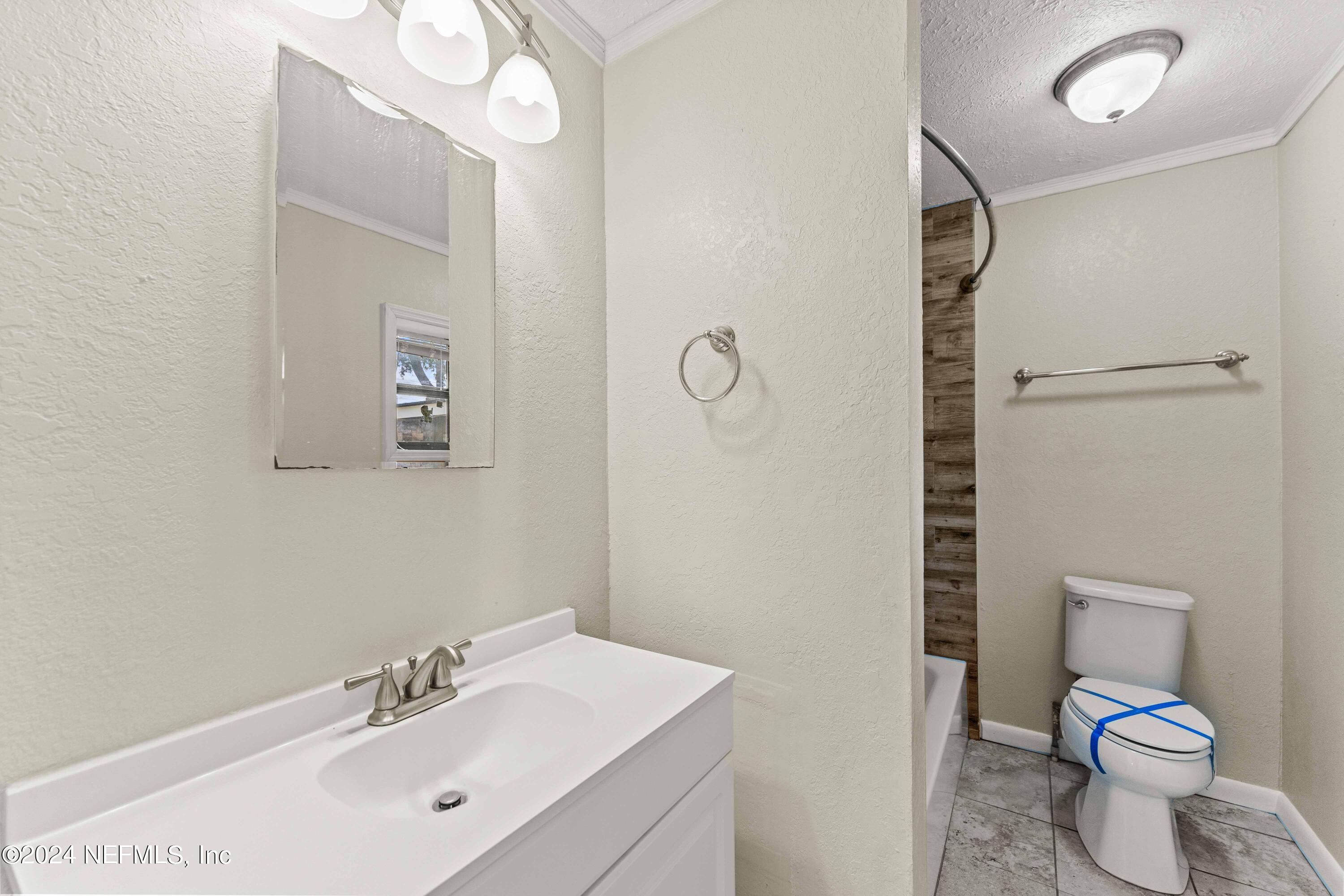 8545 Addison Road Jacksonville, FL 32208 - Photo 9 of 26 a bathroom with a toilet sink vanity and mirror