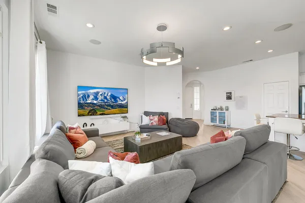 a living room with furniture kitchen and a chandelier
