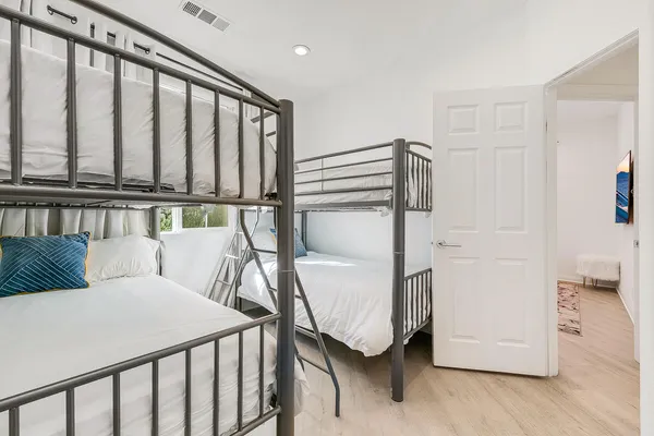 a bedroom with a bed and wooden floor