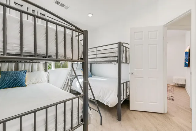 a bedroom with a bed and wooden floor