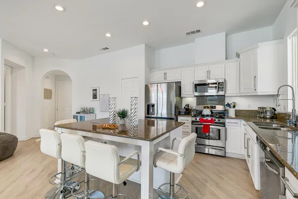 a kitchen with white cabinets and stainless steel appliances