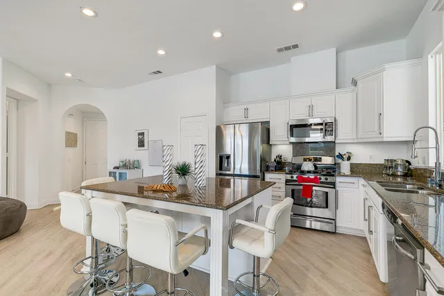 a kitchen with white cabinets and stainless steel appliances