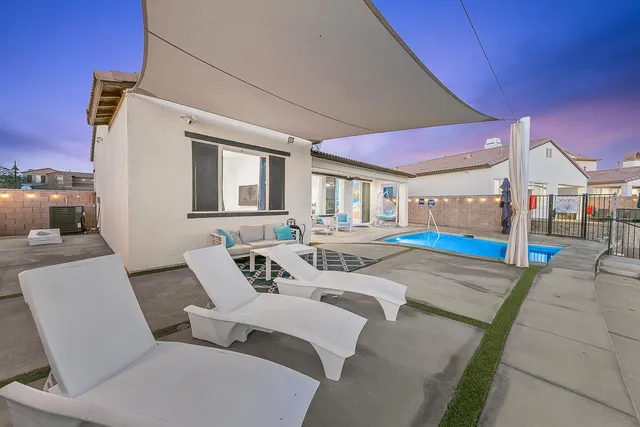 a front view of a house with a yard and potted plants