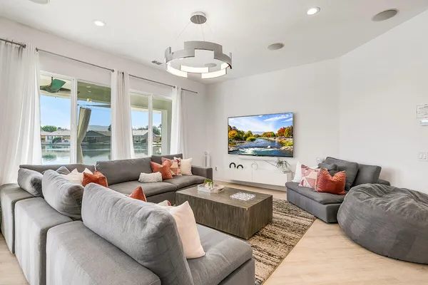 a living room with furniture kitchen and a chandelier