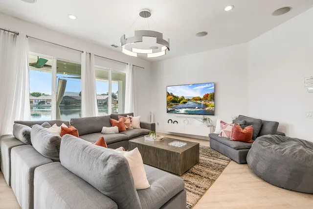 a living room with furniture kitchen and a chandelier