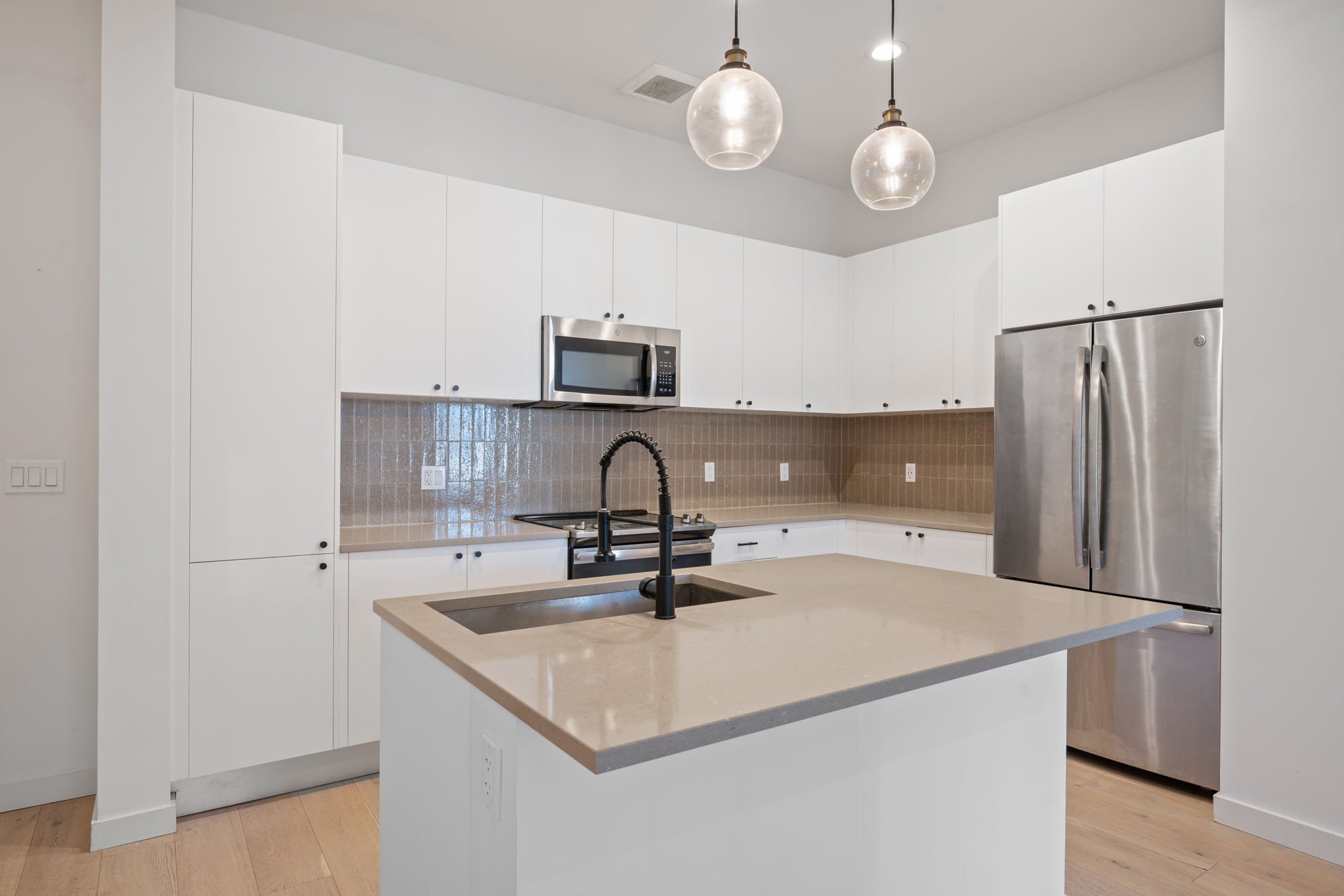 800 Embassy Drive, Unit 322 Austin, TX 78702 - Photo 3 of 31 a kitchen with kitchen island a sink stainless steel appliances and cabinets