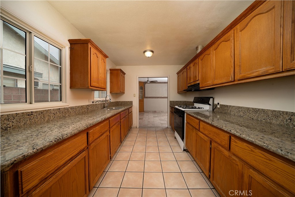 728 Geneva Street Anaheim, CA 92801 - Photo 10 of 24 a kitchen with stainless steel appliances granite countertop a sink stove and cabinets