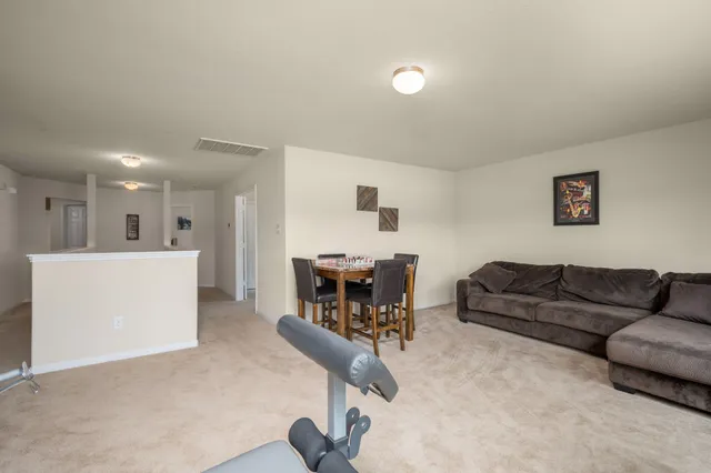 a living room with furniture and kitchen view