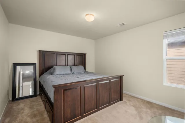 a bedroom with a granite countertop sink and cabinets