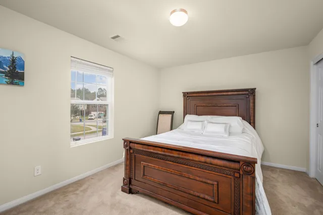 a bed sitting in a bedroom next to a window