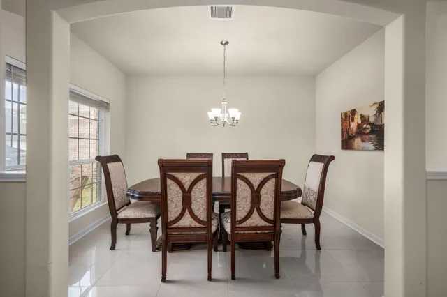 a view of a dining room with furniture and chandelier