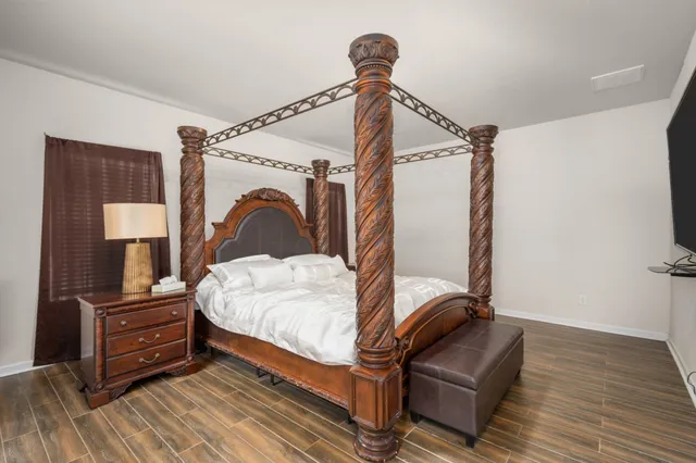 a bedroom with a bed and wooden floor