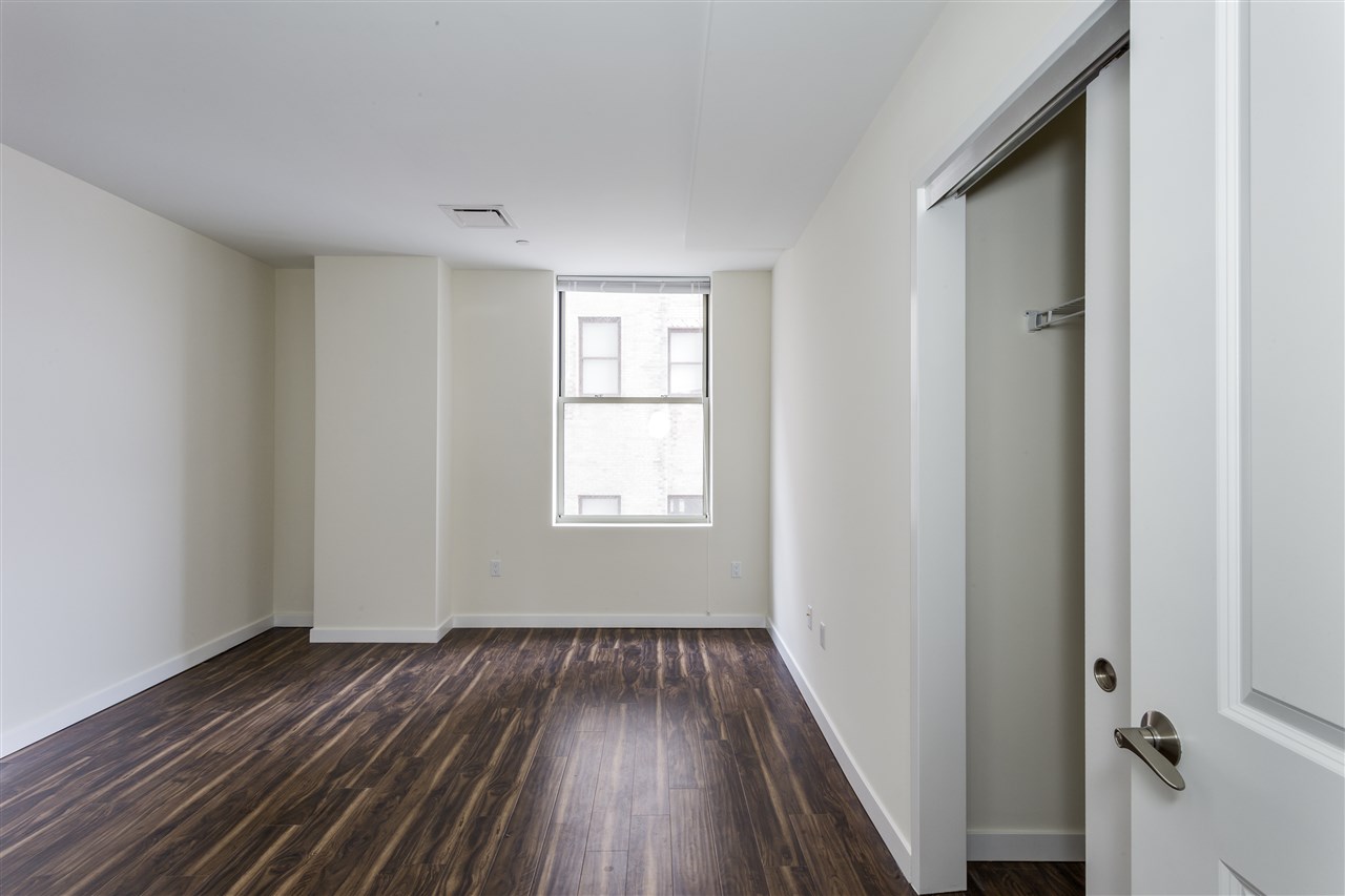88 Clifton Place, Unit 201 Jersey City, NJ 07304 - Photo 4 of 10 a view of a room with wooden floor and windows