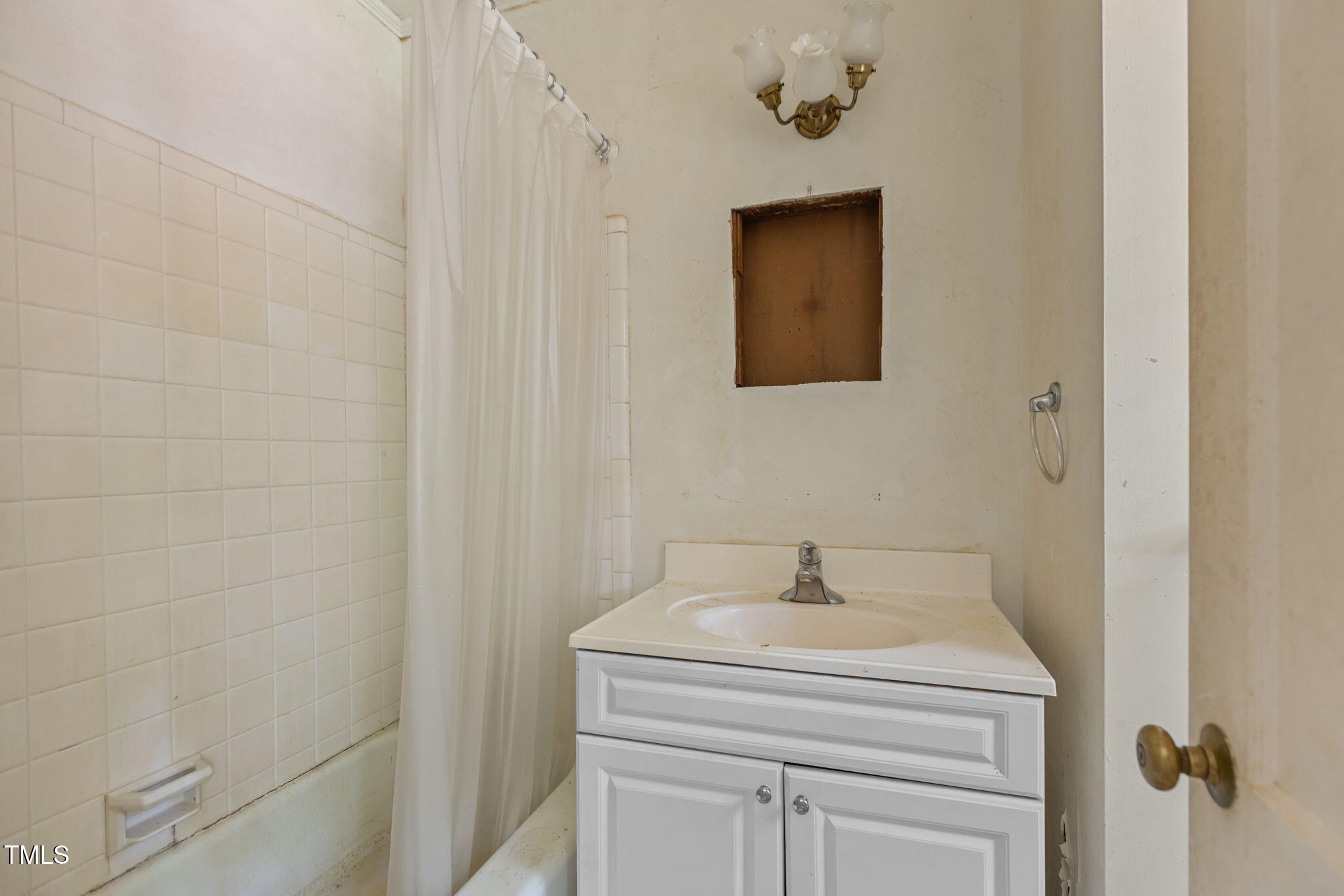 1409 Trailwood Drive Raleigh, NC 27606 - Photo 9 of 32 a bathroom with a sink a vanity and a mirror