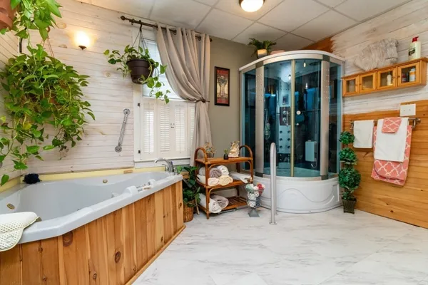 a bathroom with a tub sink and mirror