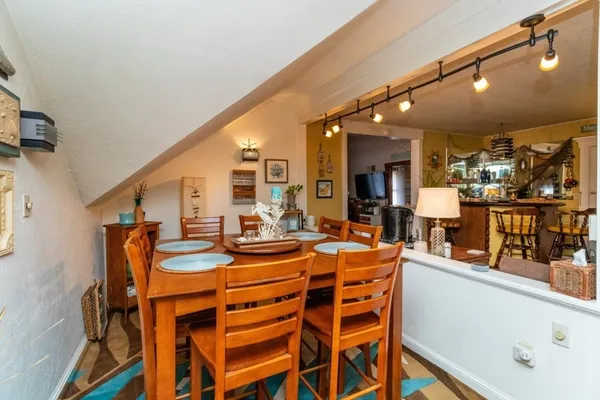 a dining hall with stainless steel appliances a dining table and chairs with wooden floor