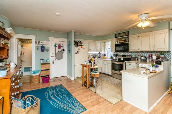 a kitchen view with microwave a stove and cabinets