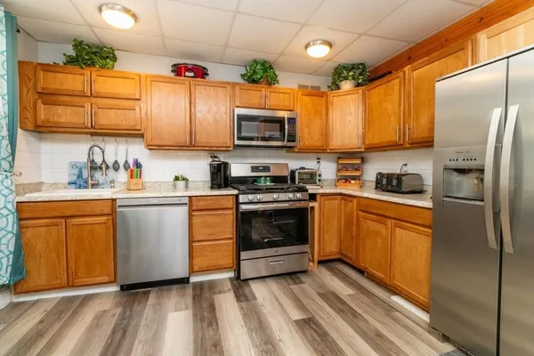 a kitchen with stainless steel appliances a refrigerator sink and microwave