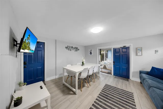 a living room with furniture a dining table and paintings on the wall