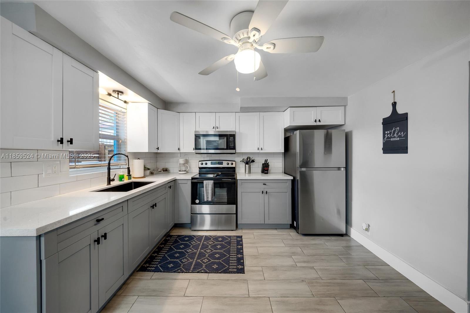817 Southwest 12th Avenue Fort Lauderdale, FL 33315 - Photo 3 of 37 a kitchen with a refrigerator a sink a stove a microwave and cabinets