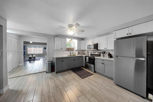 a kitchen with a refrigerator cabinets and wooden floor