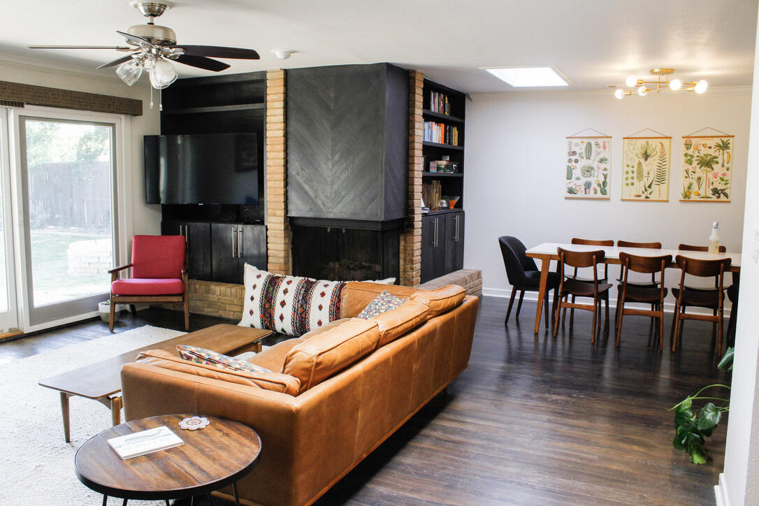 a living room with furniture kitchen view and a wooden floor