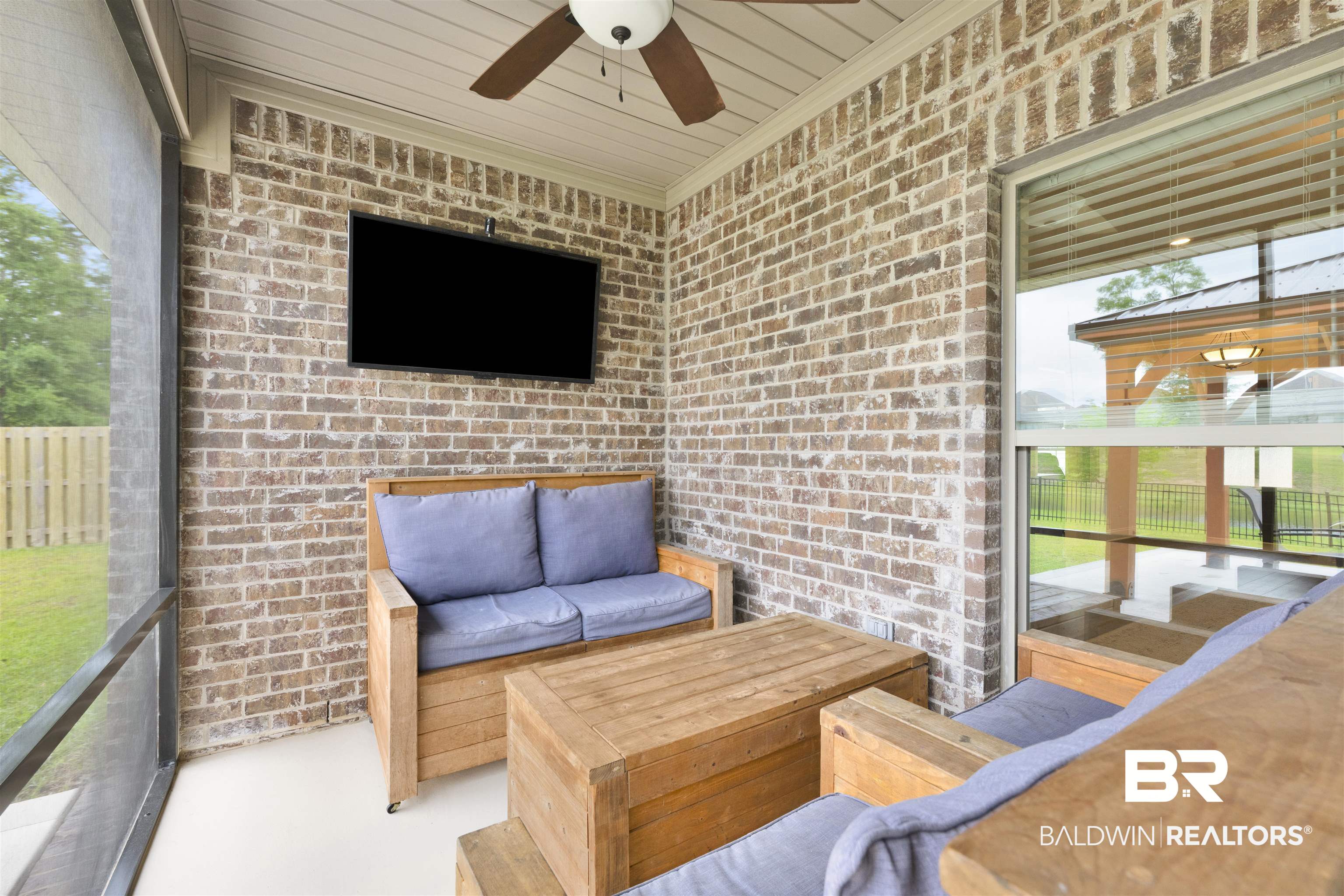 12672 Squirrel Drive Daphne, AL 36527 - Photo 35 of 49 Screened porch featuring a brick accent wall, white ceiling with a ceiling fan, and a large window overlooking the exterior