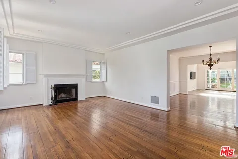 a view of a livingroom with wooden floor and a fireplace
