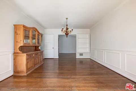 a kitchen that has a lot of cabinets and wooden floor