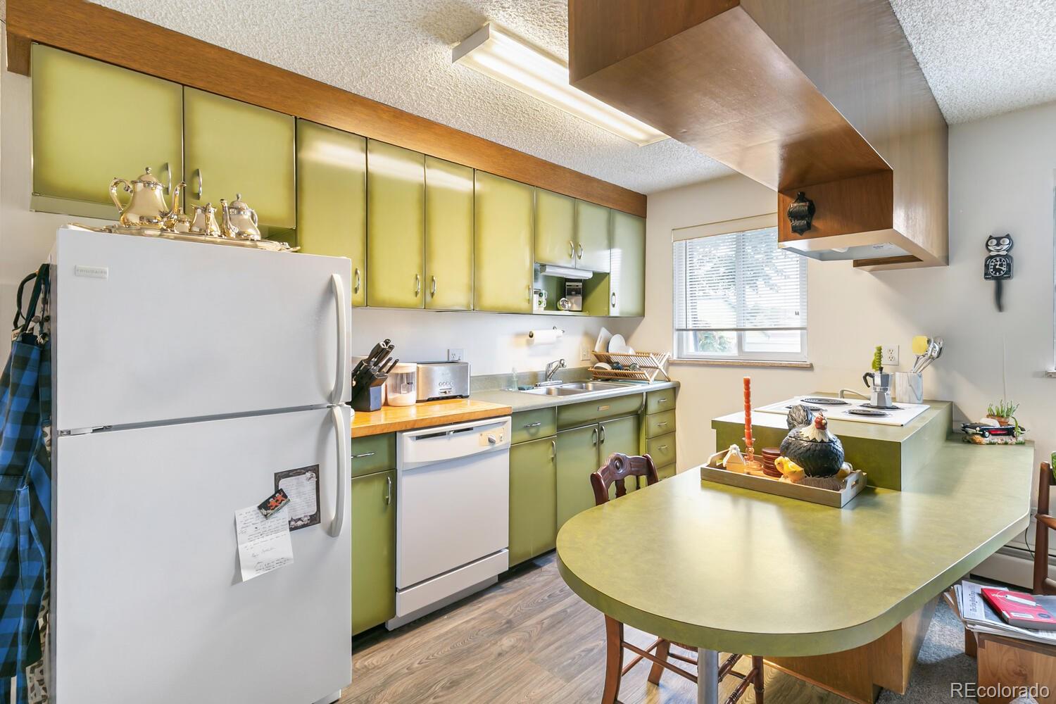 3820 Xavier Street Denver, CO 80212 - Photo 19 of 35 a kitchen with a refrigerator a stove a sink dishwasher with a dining table and chairs