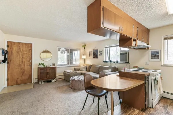 a kitchen with stainless steel appliances granite countertop a sink a stove a refrigerator a microwave oven with white cabinets and wooden floor