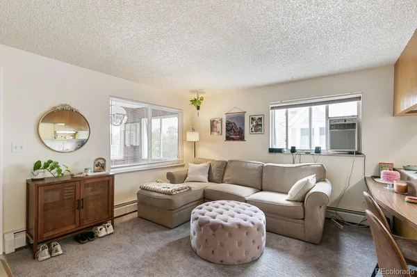 a living room with furniture and a kitchen area