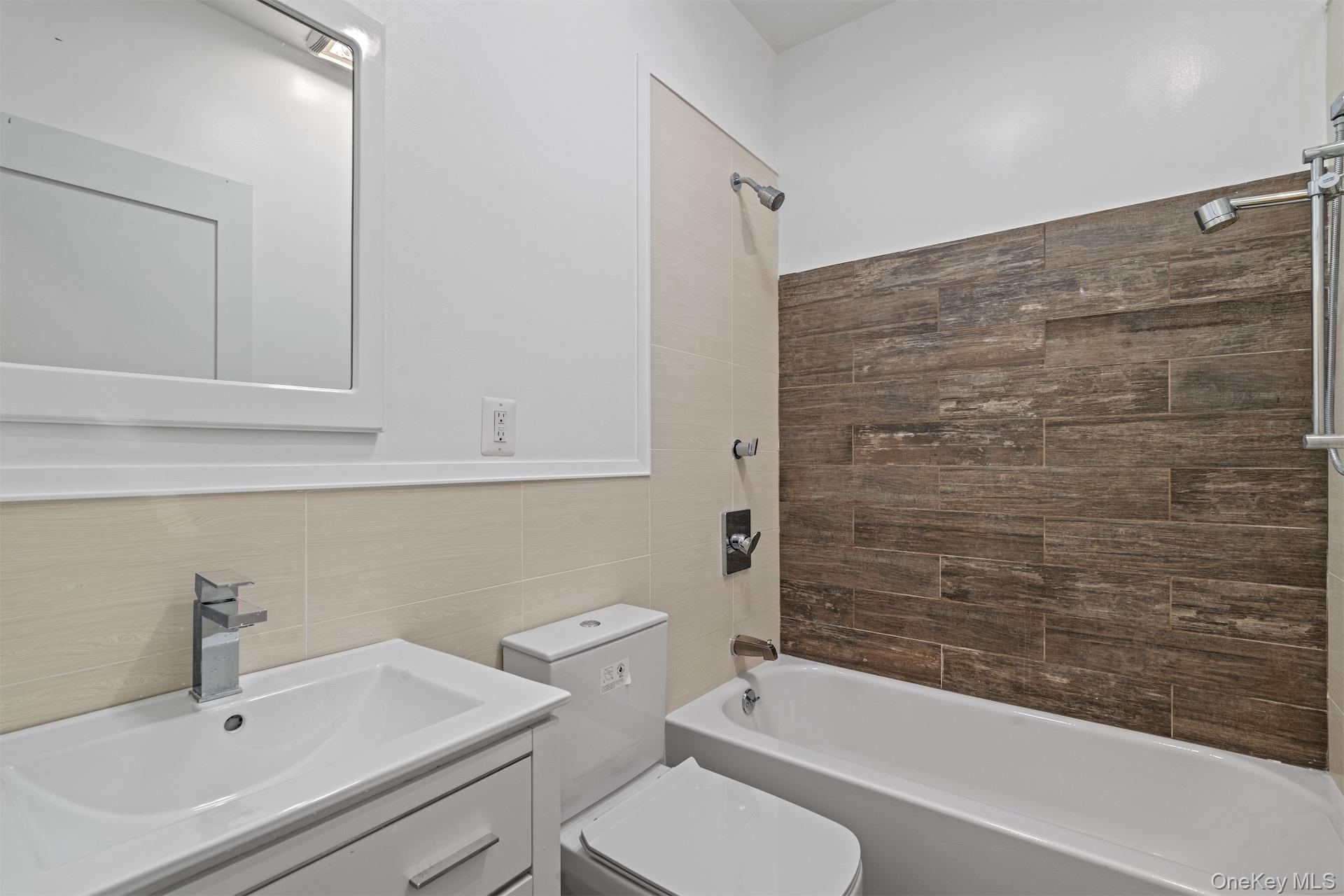 44-46 Decatur Street Brooklyn, NY 11216 - Photo 40 of 50 Full bath featuring shower / washtub combination, vanity, and tile walls