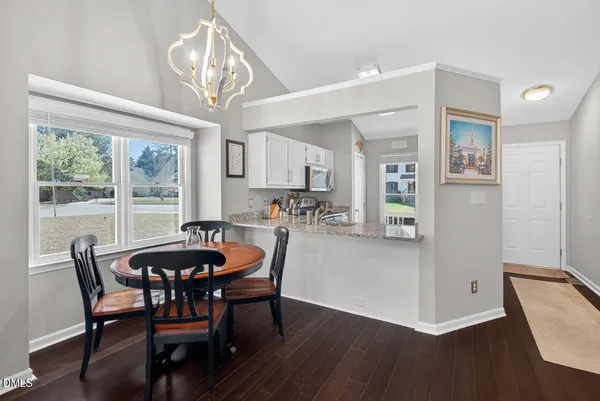 a living room with furniture a flat screen tv and kitchen view