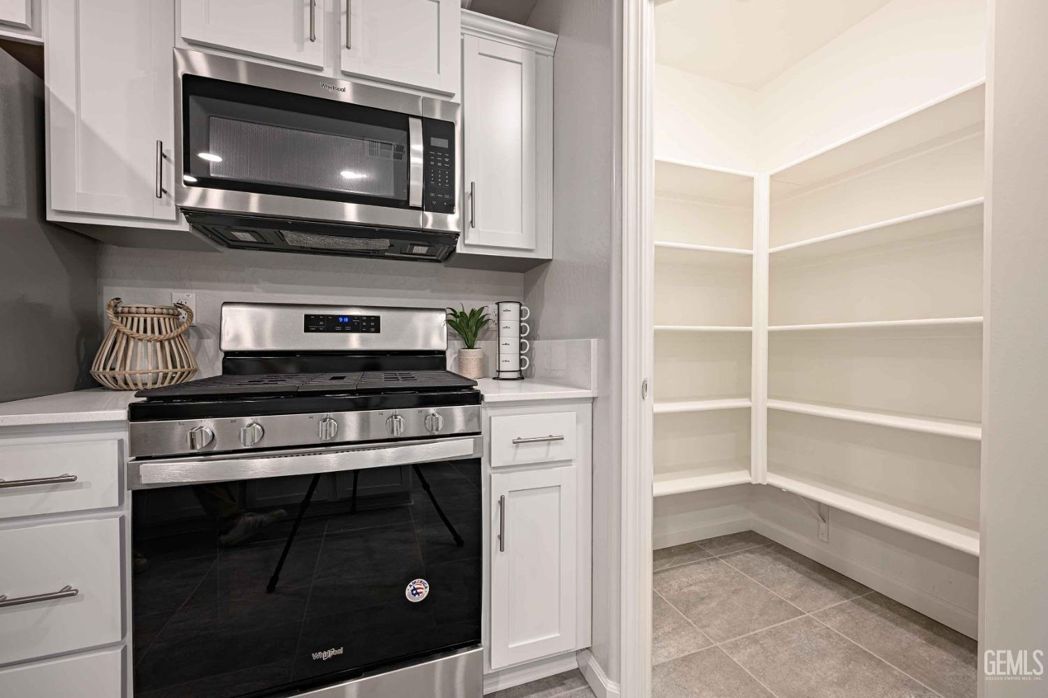 Undisclosed Address Bakersfield, CA 93313 - Photo 5 of 21 a kitchen with stainless steel appliances a stove microwave and cabinets