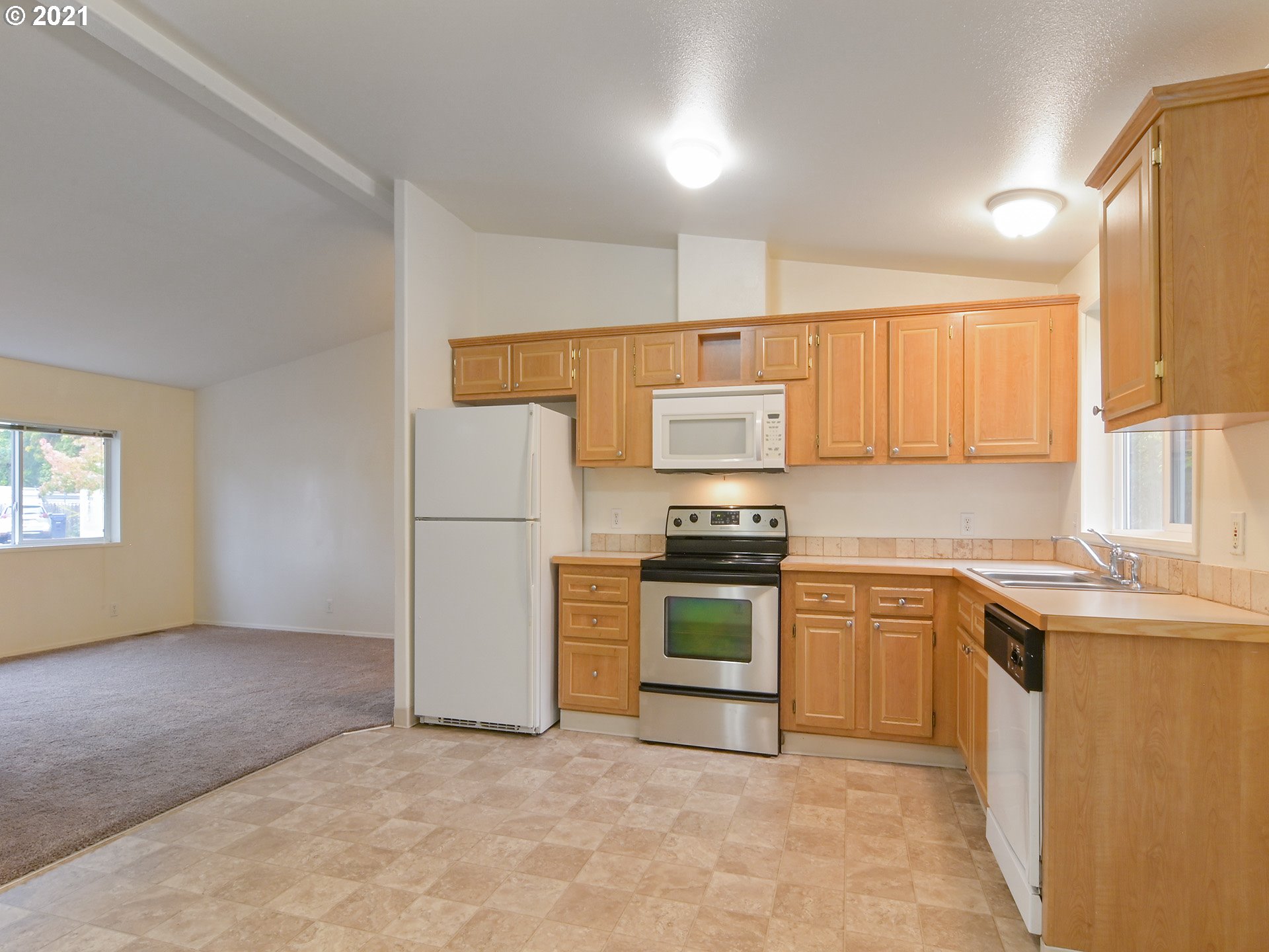 469 48th Street Springfield, OR 97478 - Photo 7 of 32 a kitchen with stainless steel appliances granite countertop a stove a sink dishwasher a refrigerator and a microwave