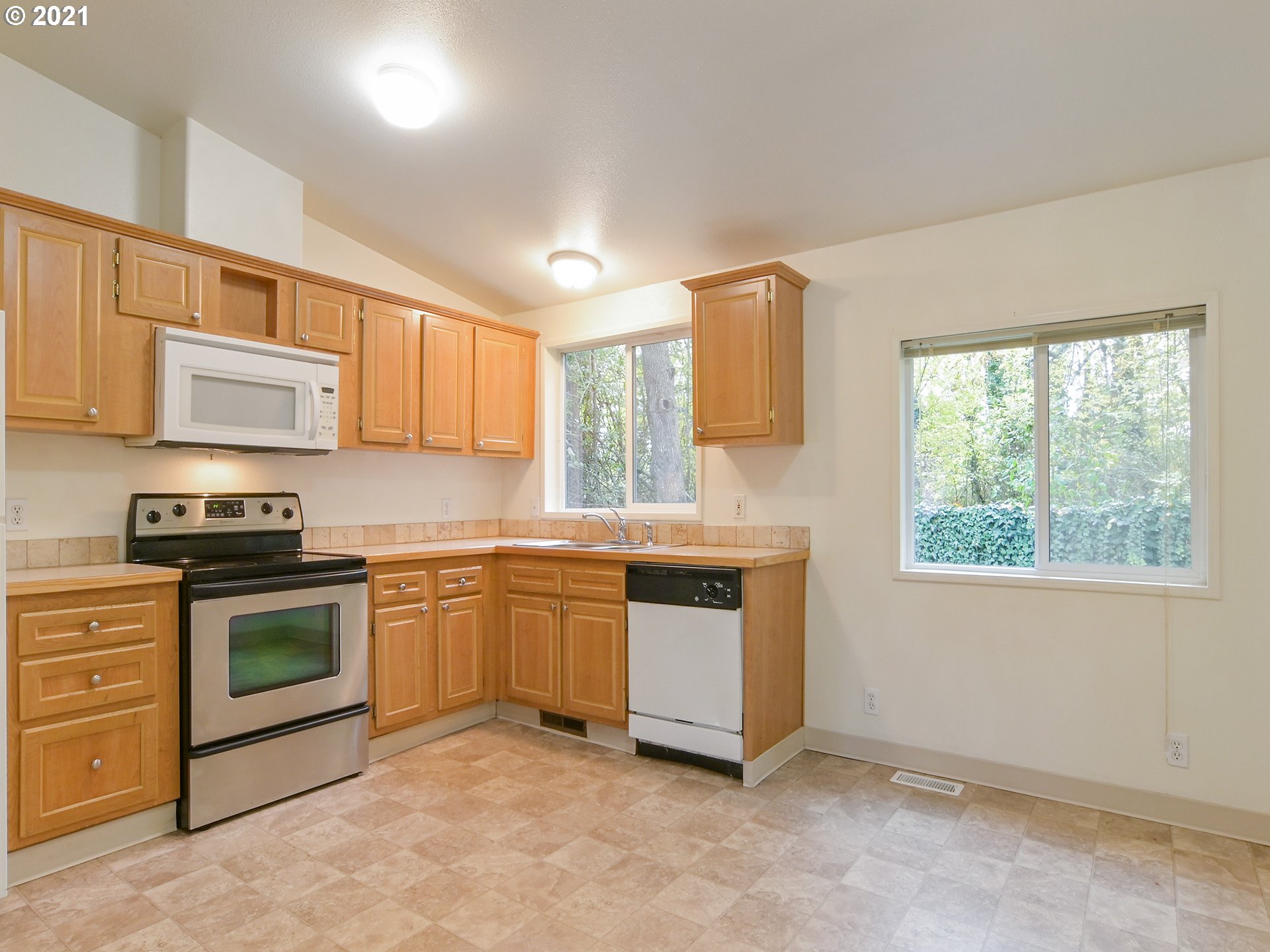 469 48th Street Springfield, OR 97478 - Photo 8 of 32 a kitchen with stainless steel appliances granite countertop a stove a sink and a microwave