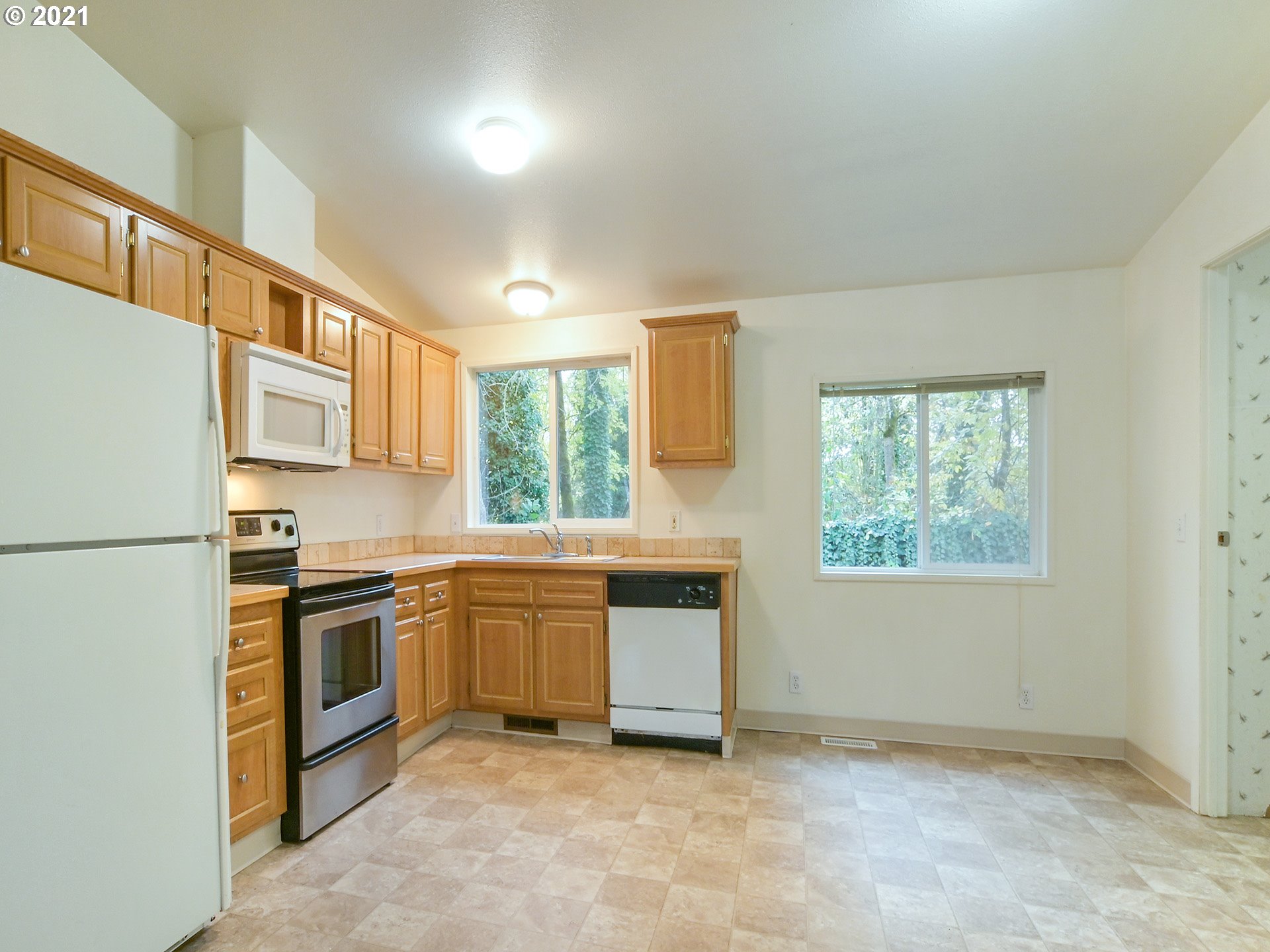 469 48th Street Springfield, OR 97478 - Photo 9 of 32 a kitchen with stainless steel appliances granite countertop a stove a sink and a refrigerator