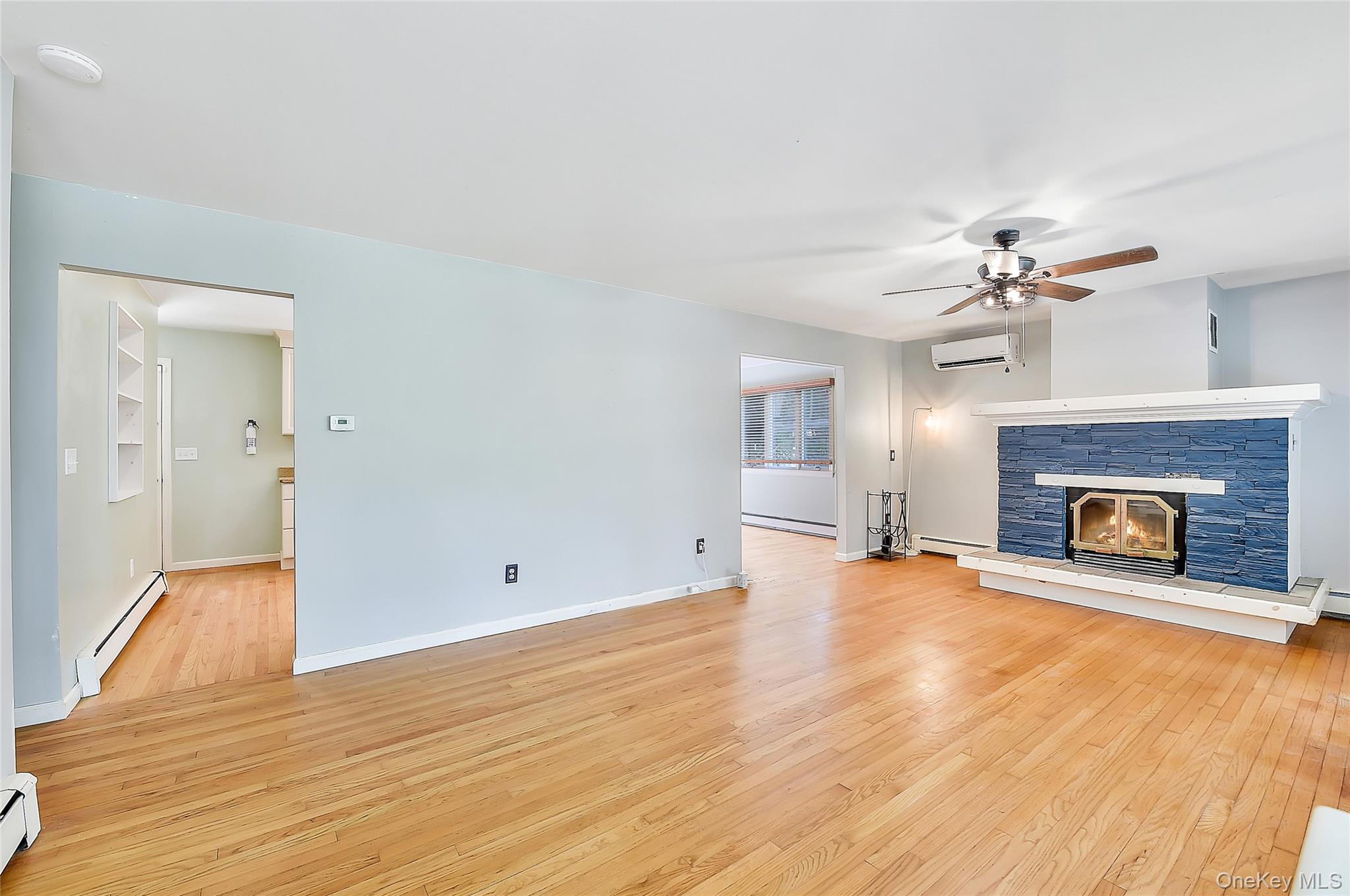 18 Stage Road Pine Island, NY 10969 - Photo 12 of 42 a view of a livingroom with a fireplace a ceiling fan and wooden floor