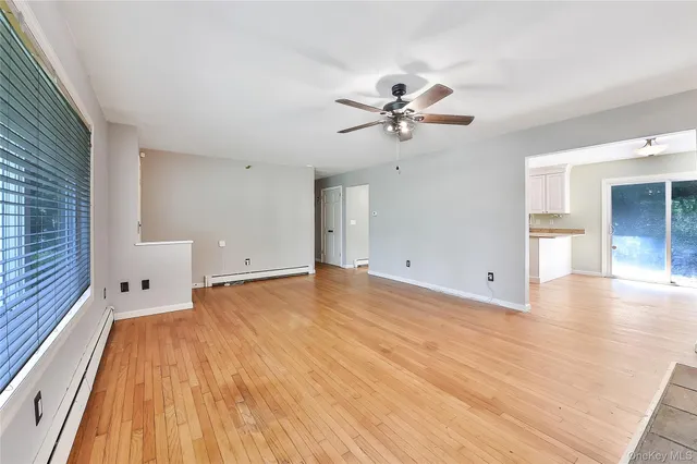 a view of a room with wooden floor and ceiling fan