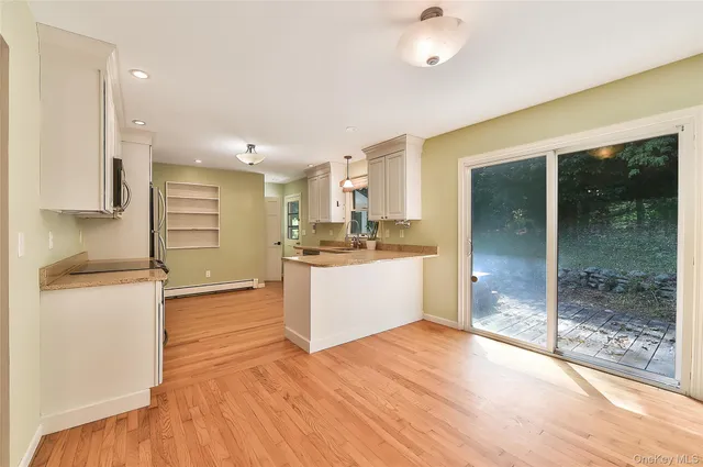 a view of a kitchen with kitchen island a sink stainless steel appliances and cabinets
