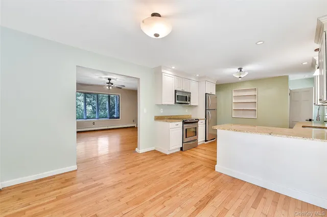 a large living room with stainless steel appliances wooden floors and view living room