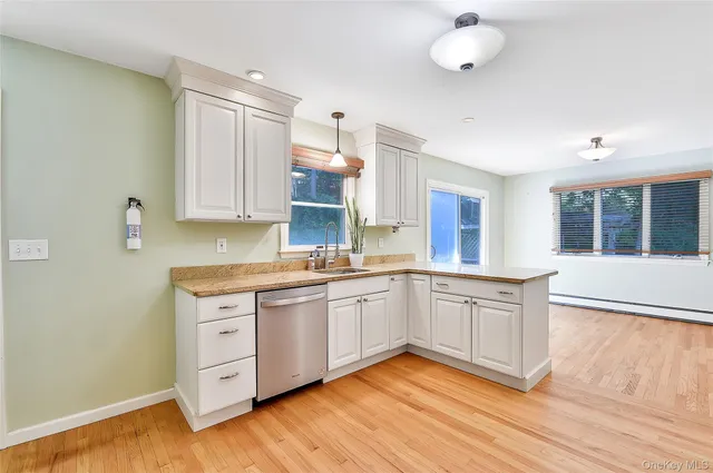 a kitchen with stainless steel appliances granite countertop a sink cabinets and wooden floor