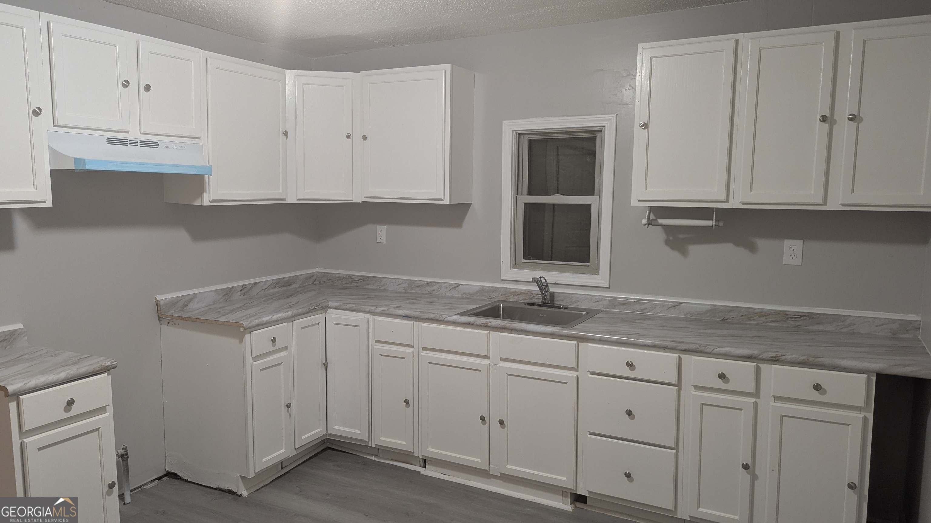 3444 Mogul Road Macon, GA 31217 - Photo 4 of 7 a kitchen with granite countertop white cabinets and a sink