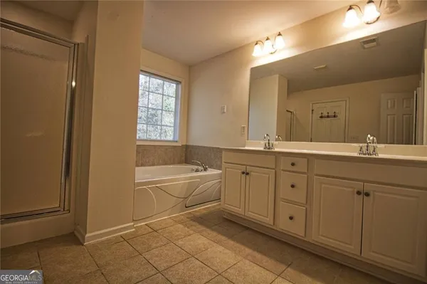 a spacious bathroom with a double vanity sink a mirror and a bathtub