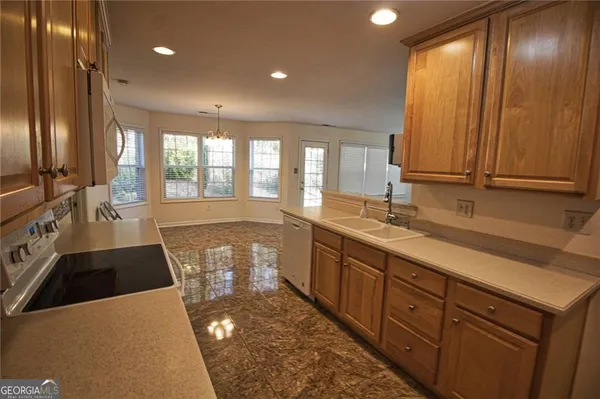 a large kitchen with granite countertop a sink and a large window
